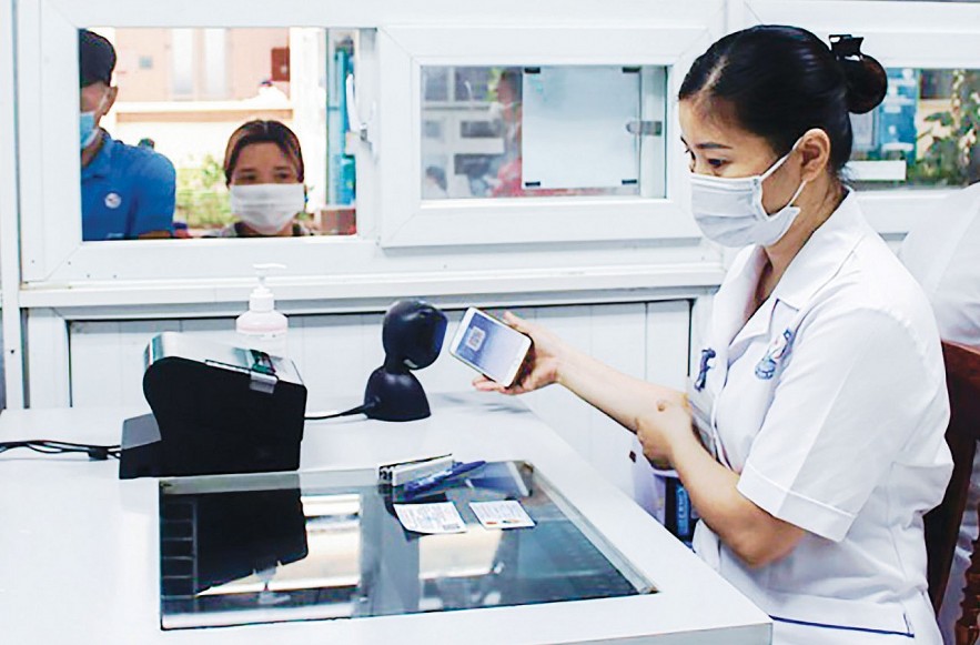 Nhân viên y tế quét mã QR qua hình ảnh thẻ bảo hiểm y tế trên ứng dụng VssID để thực hiện các thủ tục khám chữa bệnh cho người dân.