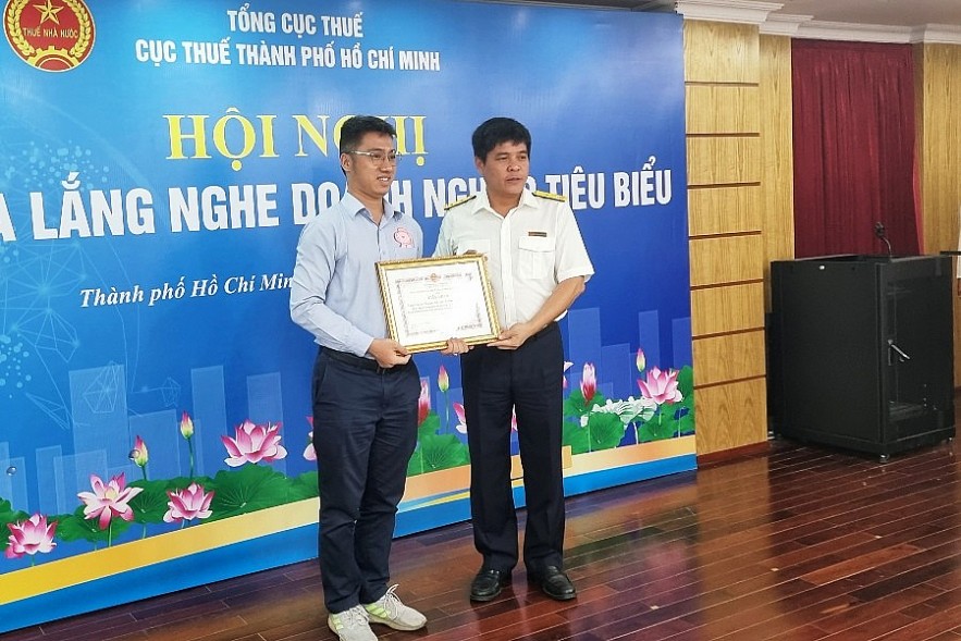 Phó Cục trưởng Cục Thuế TP. Hồ Chí Minh Thái Minh Giao (phải) tuyên dương một doanh nghiệp thực hiện tốt nghĩa vụ thuế. Ảnh Đỗ Doãn