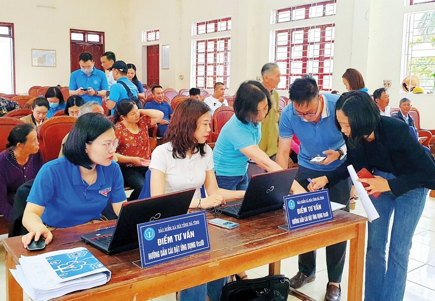Cán bộ ngành Bảo hiểm xã hội Việt Nam hướng dẫn, hỗ trợ người dân về ứng dụng VssID. Ảnh: BHXHVN
