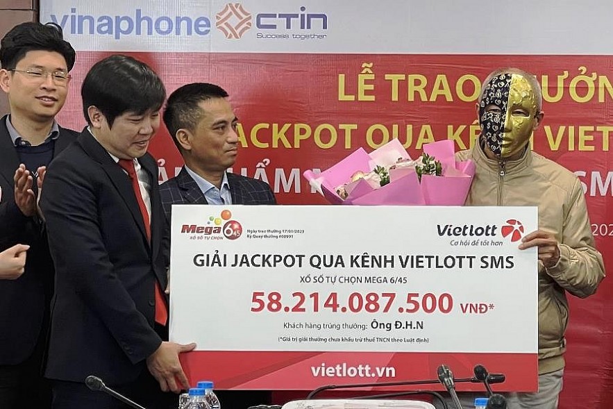 Đại diện Vietlott trao giải Jackpot Mega 6/45 trị giá 58,2 tỷ đồng cho ông Đ.H.N. Ảnh Diệu Hồng