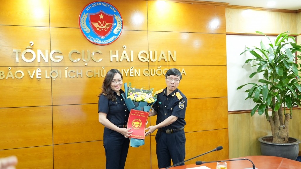 Phó Tổng cục trưởng Lưu Mạnh Tưởng trao quyết định, tặng hoa chúc mừng bà Trần Thị Minh Huệ.