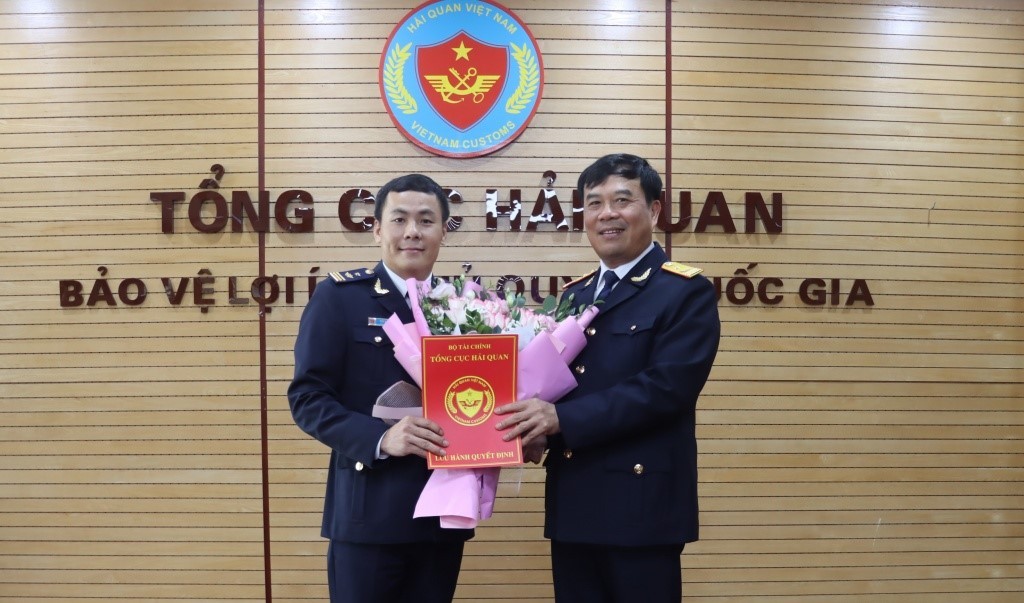 Phó Tổng cục trưởng Nguyễn Văn Thọ (phải) trao quyết định và tặng hoa chúc mừng tân Phó Cục trưởng Trần Xuân Lộc. Ảnh: T.Bình.