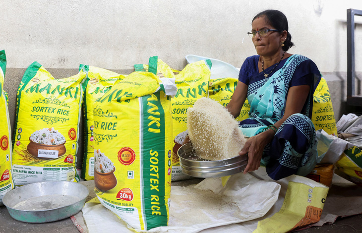 Một người phụ nữ sàng gạo tại một khu chợ ở Navi Mumbai, Ấn Độ ngày 4-8 - Ảnh: REUTERS