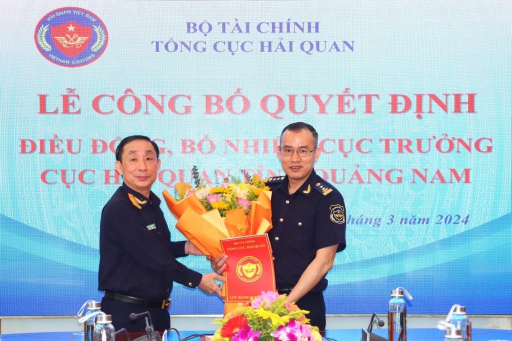 Phó Tổng cục trưởng Hoàng Việt Cường (bên trái) trao quyết định bổ nhiệm và tặng hoa chúc mừng tân Cục trưởng Dương Xuân Sinh