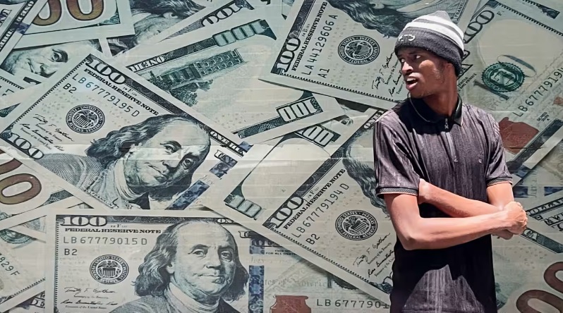 Một người đ&agrave;n &ocirc;ng đứng b&ecirc;n ngo&agrave;i văn ph&ograve;ng đổi tiền ở trung t&acirc;m th&agrave;nh phố Nairobi, Kenya. Ảnh: Reuters