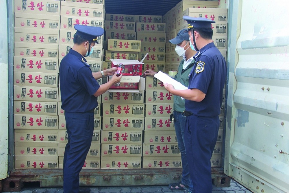 Công chức Cục Hải quan TPHCM kiểm tra thực phẩm nhập khẩu. Ảnh: T.H