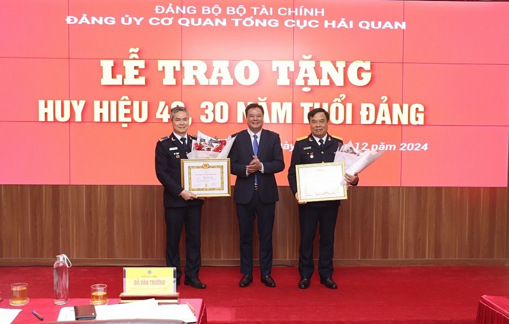 Tại hội nghị, Phó Bí thư thường trực Đảng ủy Bộ Tài chính Đỗ Văn Trường đã trao Huy hiệu 40 năm tuổi Đảng cho một số đồng chí thuộc Đảng bộ Tổng cục Hải quan. Trong ảnh: Phó Bí thư thường trực Đảng ủy Bộ Tài chính trao Huy hiệu 40 năm tuổi Đảng và tặng hoa chúc mừng Tại hội nghị, Phó Bí thư thường trực Đảng ủy Bộ Tài chính Đỗ Văn Trường đã trao Huy hiệu 40 năm tuổi Đảng cho một số đồng chí thuộc Đảng bộ Tổng cục Hải quan. Trong ảnh: Phó Bí thư thường trực Đảng ủy Bộ Tài chính trao Huy hiệu 40 năm tuổi Đảng và tặng hoa chúc mừng
