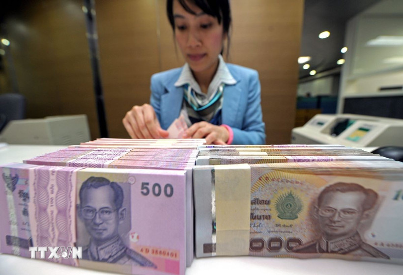 Kiểm tiền baht của Thái Lan tại ngân hàng ở Bangkok. (Ảnh: AFP/ TTXVN)
