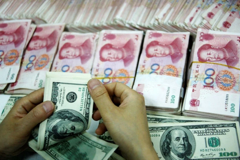 Trung Quốc gom mạnh USD để hạ nhiệt đà tăng nóng của đồng nội tệ Nhân viên kiểm đồng USD và đồng nhân dân tệ. (Ảnh: AFP/TTXVN)