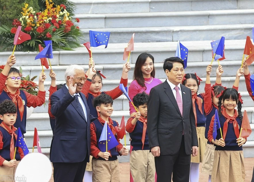 Chuyến thăm của Chủ tịch Hội đồng châu Âu diễn ra vào thời điểm có ý nghĩa rất quan trọng khi Việt Nam vừa tổ chức thành công Đại hội đại biểu toàn quốc lần thứ XIV và hai bên đã kỷ niệm 35 năm thiết lập quan hệ ngoại giao vào năm 2025 (28/11/1990-28/11/2025). Trong ảnh Chủ tịch nước Lương Cường và Chủ tịch Hội đồng châu Âu chụp ảnh chung với các em thiếu nhi Việt Nam tại sân trước Phủ Chủ tịch.
