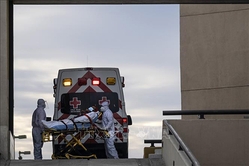 Nhân viên y tế chuyển bệnh nhân mắc COVID-19 lên xe cứu thương