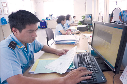 Cán bộ hải quan rà soát hồ sơ XNK của DN, phục vụ công tác hậu kiểm.