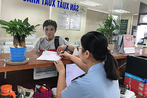 Cán bộ hải quan hướng dẫn DN cách thức áp dụng Danh mục HH XNK VN. Ảnh: HẢI ANH