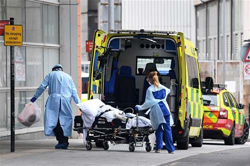 Nhân viên y tế chuyển bệnh nhân COVID-19 vào bệnh viện ở London