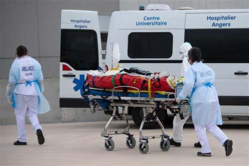 Nhân viên y tế chuyển bệnh nhân COVID-19 lên xe cứu thương tại Angers, Pháp ngày 15/3/2021.