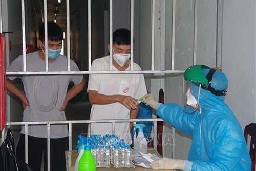 Nhân viên y tế tiến hành lấy mẫu xét nghiệm cho những người nhập cảnh.