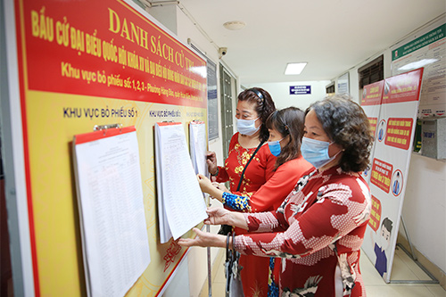 Người dân theo dõi danh sách niêm yết cử tri tại trụ sở HĐND, UBND phường Hàng Đào (Hà Nội).