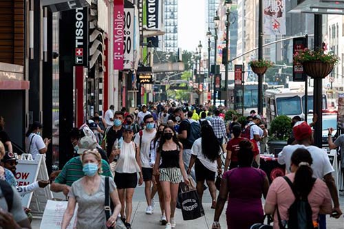 Người dân di chuyển trên một tuyến phố mua sắm ở New York, Mỹ ngày 7/6/2021.