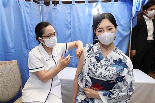 Nhân viên y tế tiêm vaccine ngừa COVID-19 cho người dân tại Tokyo