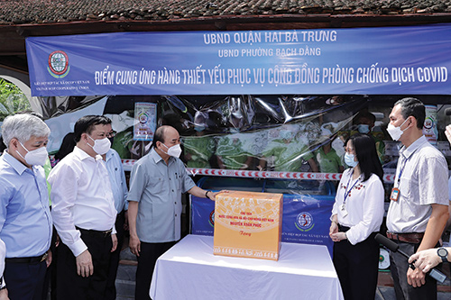 Chủ tịch nước Nguyễn Xuân Phúc tặng quà tại Điểm cung ứng hàng thiết yếu phục vụ cộng đồng