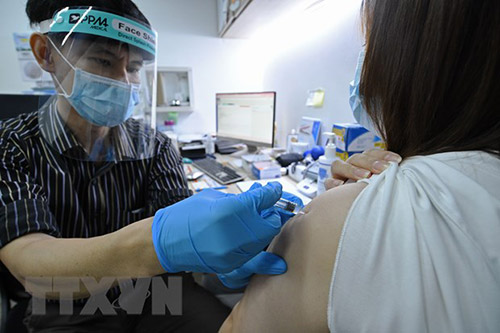 Nhân viên y tế tiêm vaccine phòng COVID-19 cho người dân tại Singapore.
