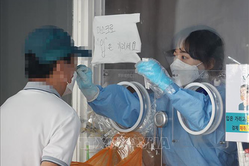 Nhân viên y tế lấy mẫu xét nghiệm COVID-19 cho người dân tại Seoul, Hàn Quốc