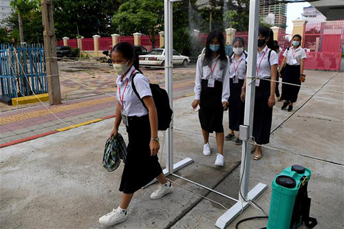 Học sinh đeo khẩu trang và được khử khuẩn để phòng lây nhiễm COVID-19 tại một trường học