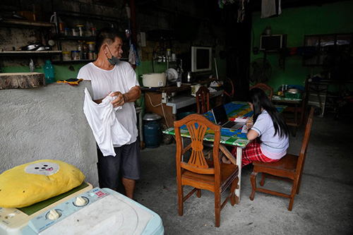 Một học sinh học trực tuyến bằng máy tính xách tay ở nhà tại thành phố Quezon