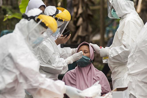 Nhân viên y tế lấy mẫu xét nghiệm COVID-19 cho người dân tại Yogyakarta, Indonesia, ngày 14/6/2021.