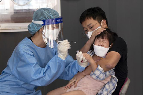 Nhân viên y tế lấy mẫu xét nghiệm COVID-19 cho người dân tại Seoul, Hàn Quốc