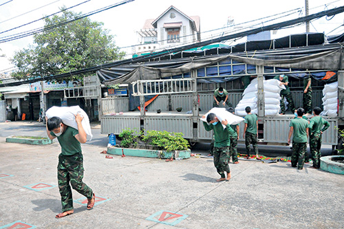 Lực lượng bộ đội Quân khu 7 hỗ trợ bốc xếp gạo tại phường 13, quận Gò Vấp.