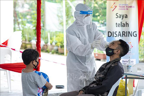 Nhân viên y tế lấy mẫu xét nghiệm COVID-19 cho người dân tại Taman Muda gần Kuala Lumpur, Malaysia.