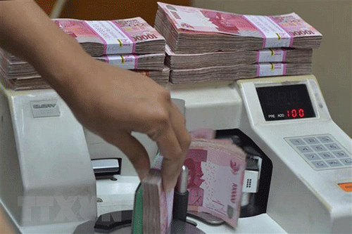 Kiểm đồng rupiah tại một cửa hàng đổi tiền ở Jakarta.