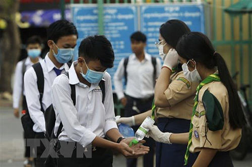 Học sinh Campuchia khử trùng tay trước khi vào lớp.