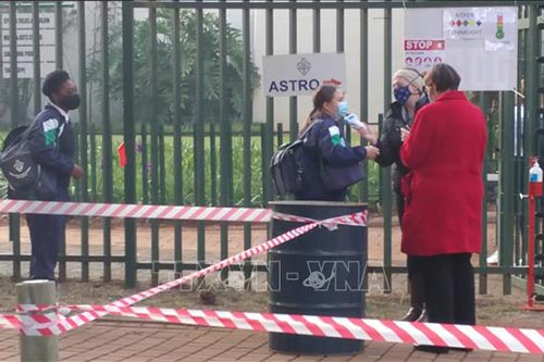 Kiểm tra thân nhiệt cho học sinh trước khi vào lớp tại trường Trung học nữ sinh Pretoria, Nam Phi.